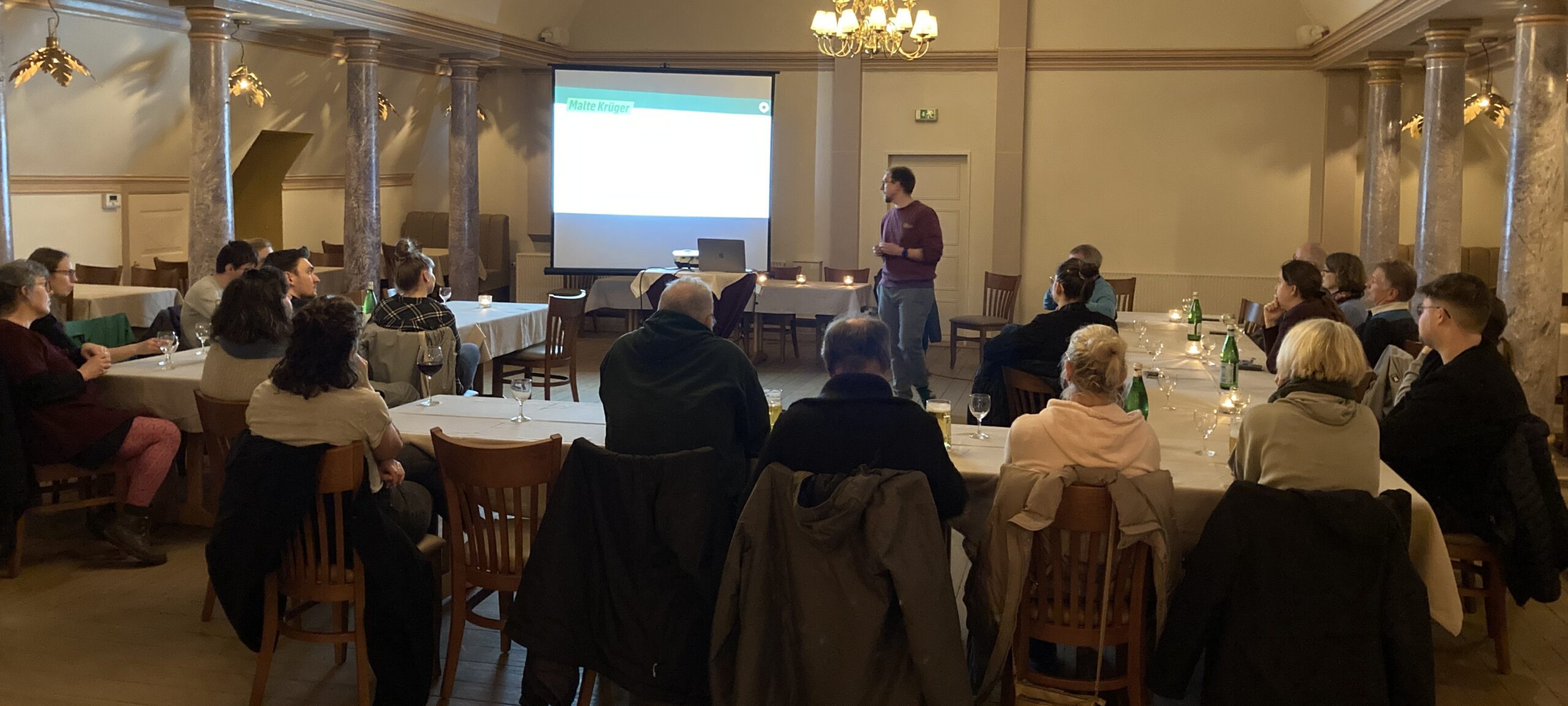 Malte Krüger hält vor einem interessierten Publikum einen Vortrag